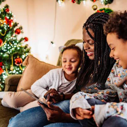 Kids watching cartoons with mom on tablet or having video call. Christmas time.